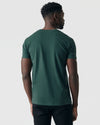 Man wearing Forest Green V-Neck Tee, showcasing its fitted style.