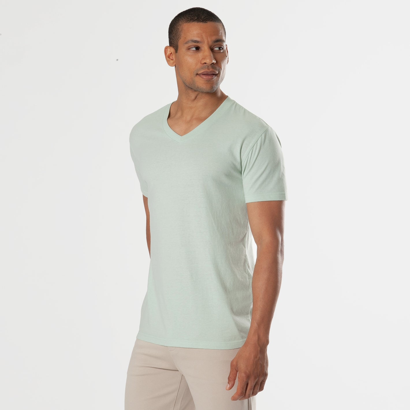 Man wearing Green Lapis V-Neck Tee and beige trousers.