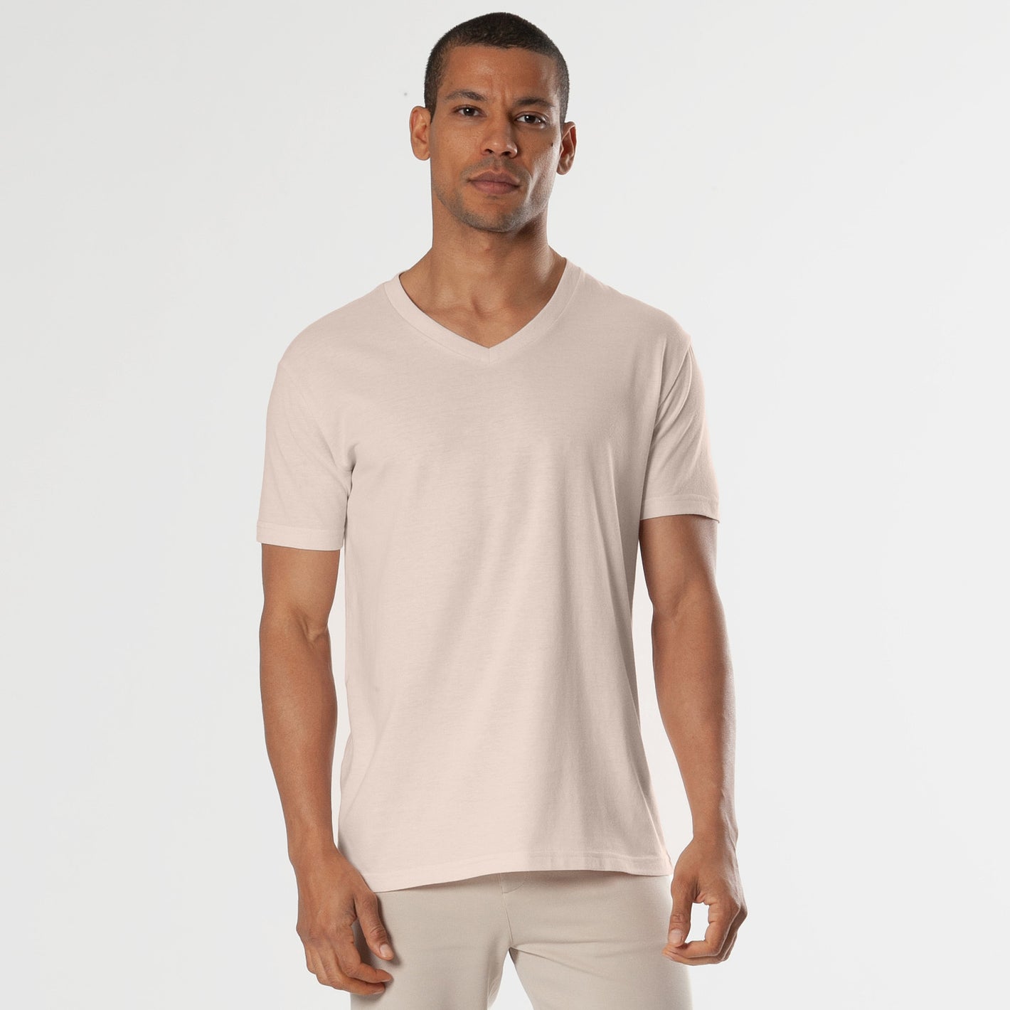 Model wearing Pink Opal V-Neck Tee with fitted light pants.