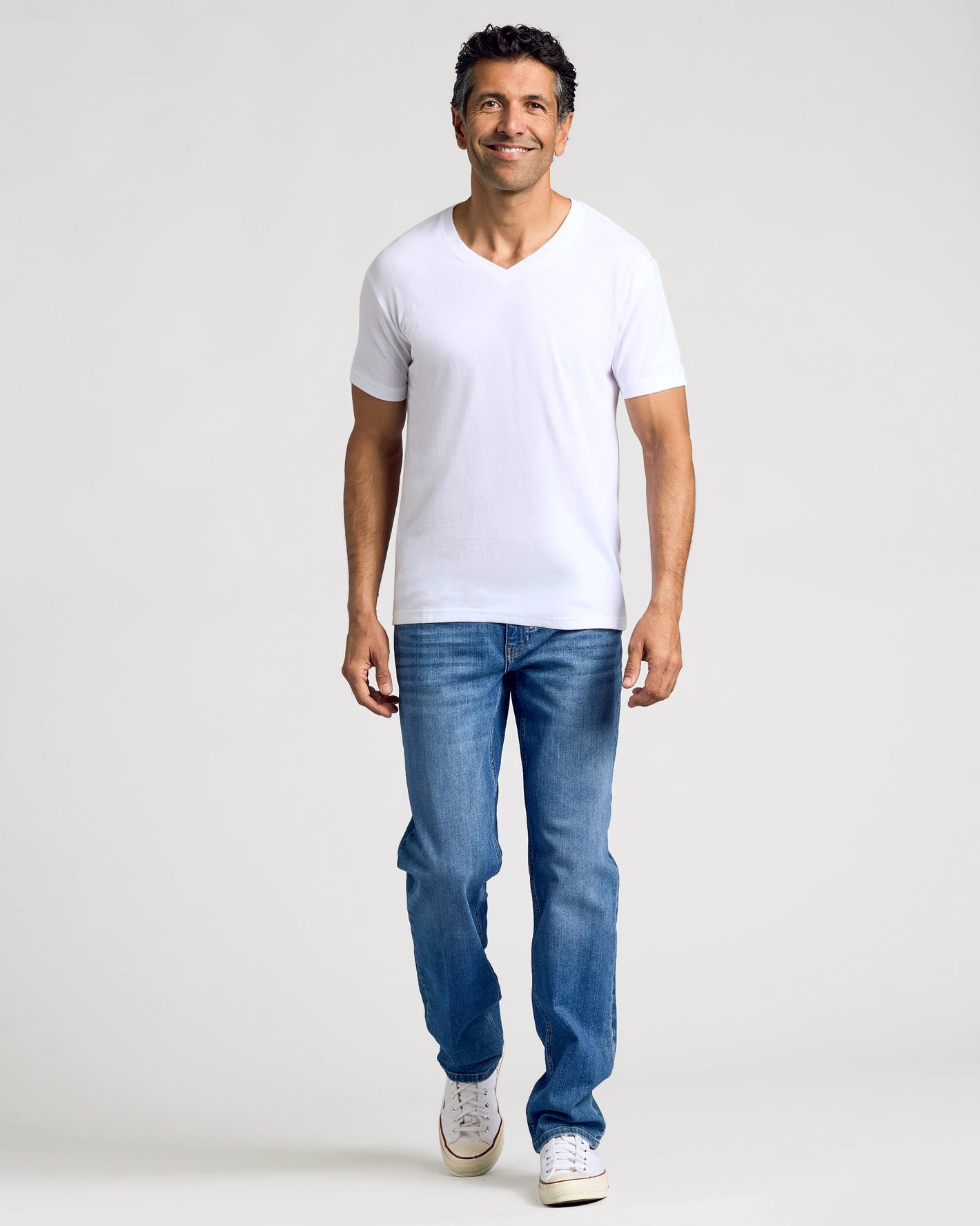 Man in All White Classic V-Neck T-Shirt, relaxed and smiling.