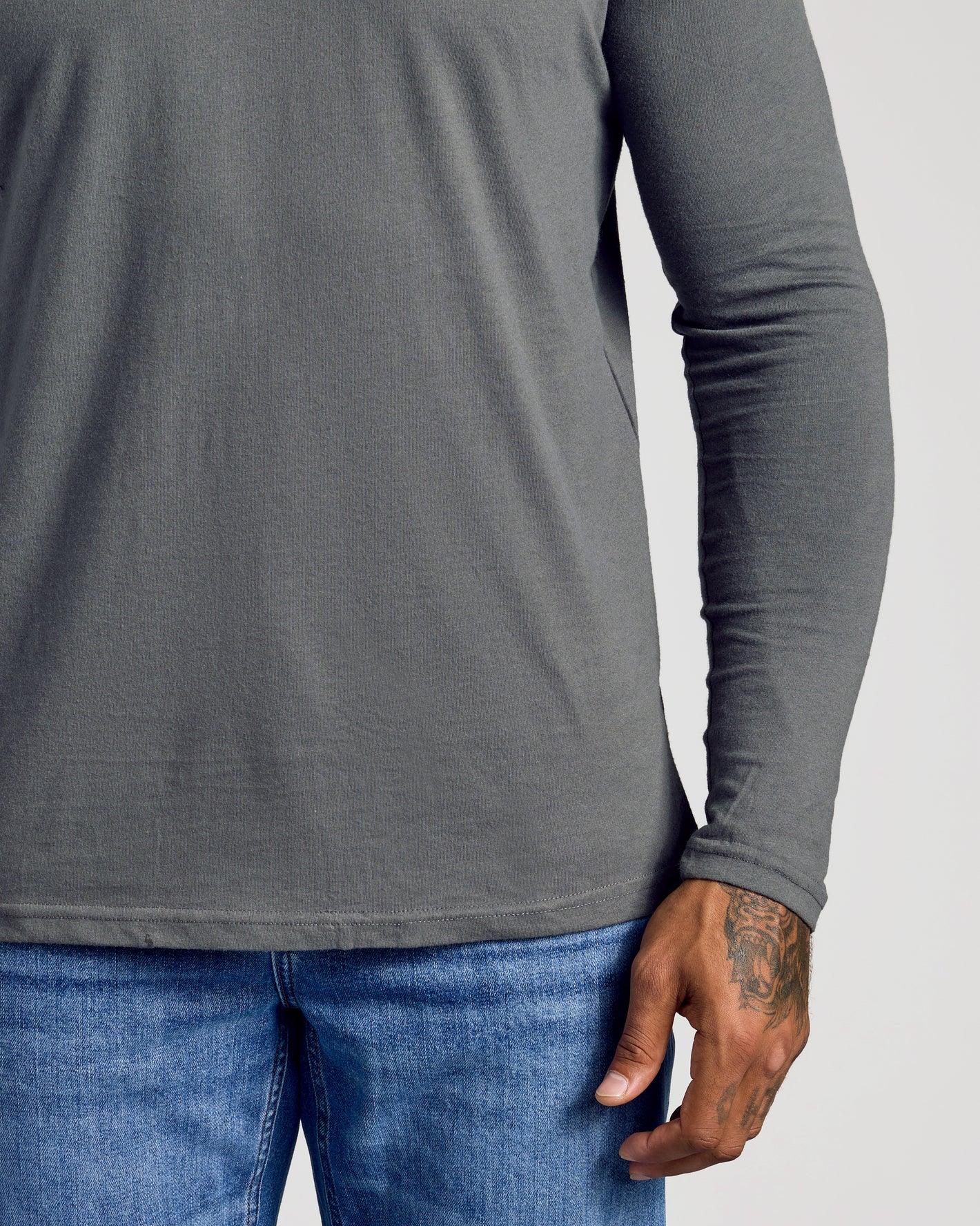 Classic Long Sleeve 3-Pack worn with blue jeans, showcasing tattooed hand.