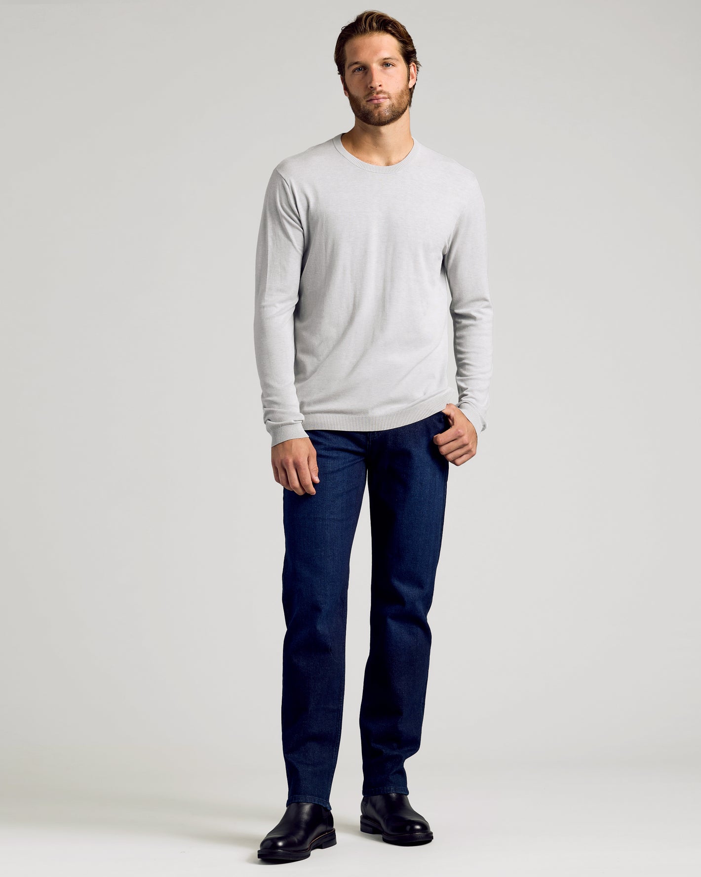 Man wearing Dressy Crew Neck Sweater 3-Pack, jeans, and boots.