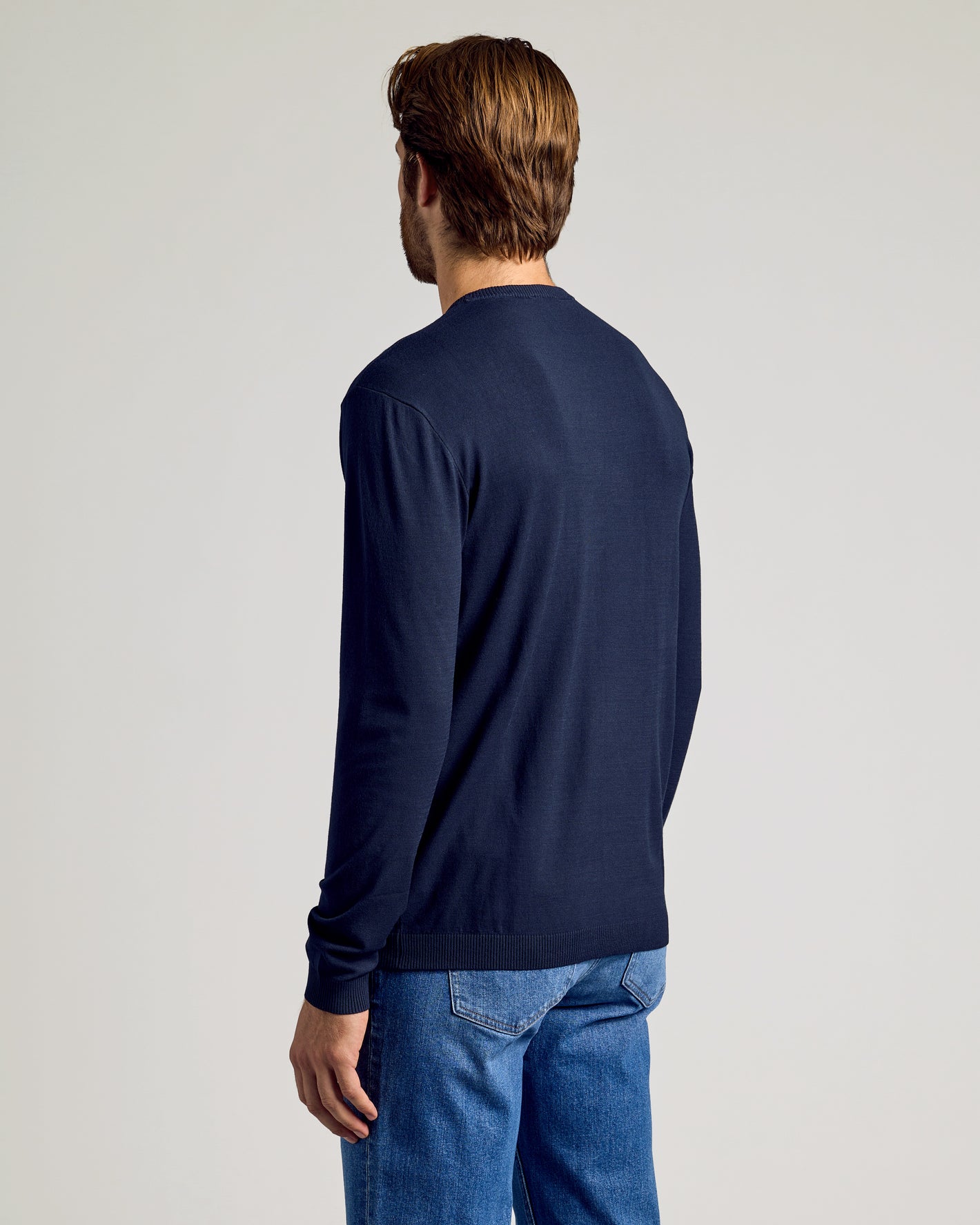Man wearing Navy Dressy Crew Neck Sweater, showcasing slim fit from behind.