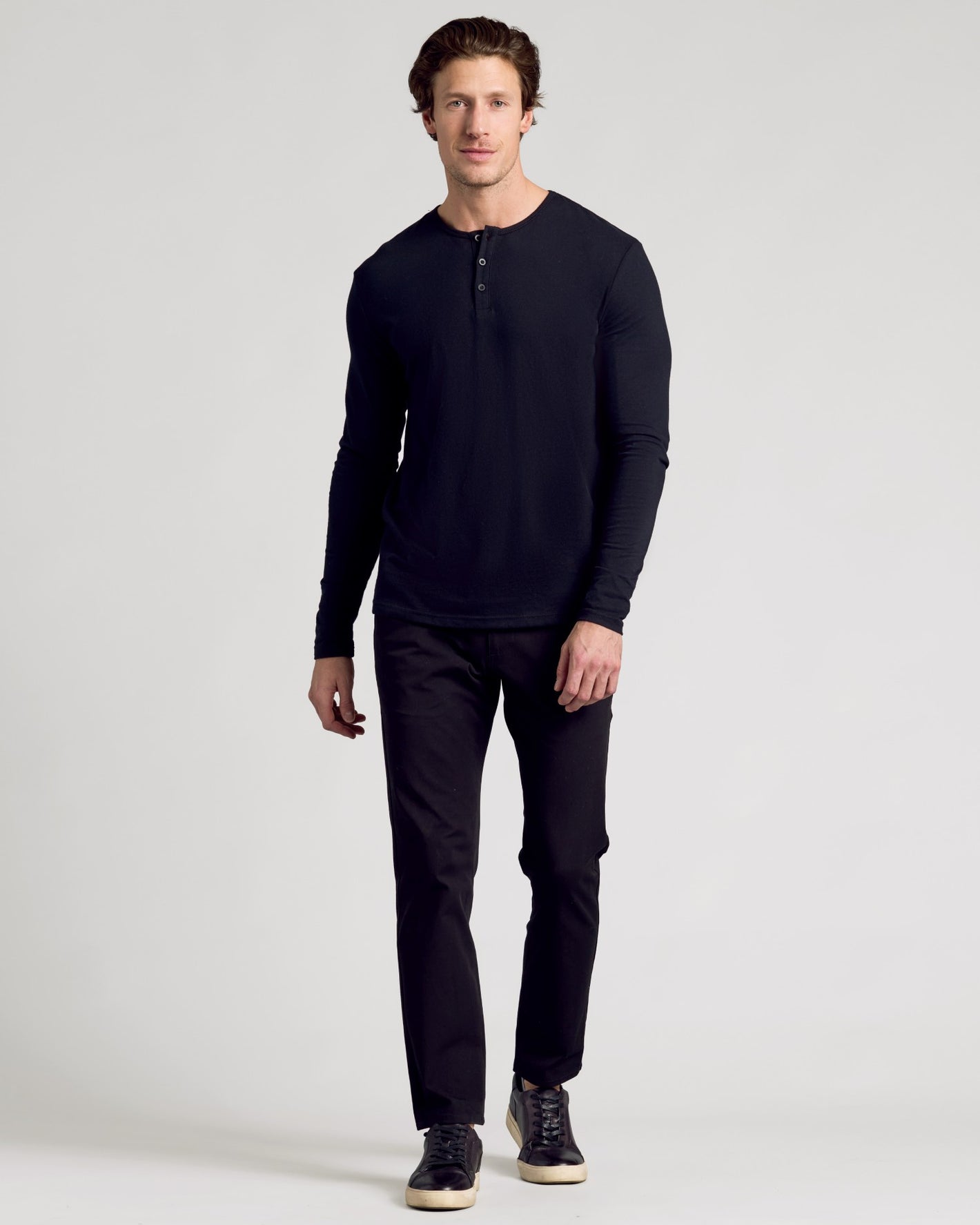 Man wearing All Black Classic Henley 6-Pack with trousers and sneakers.