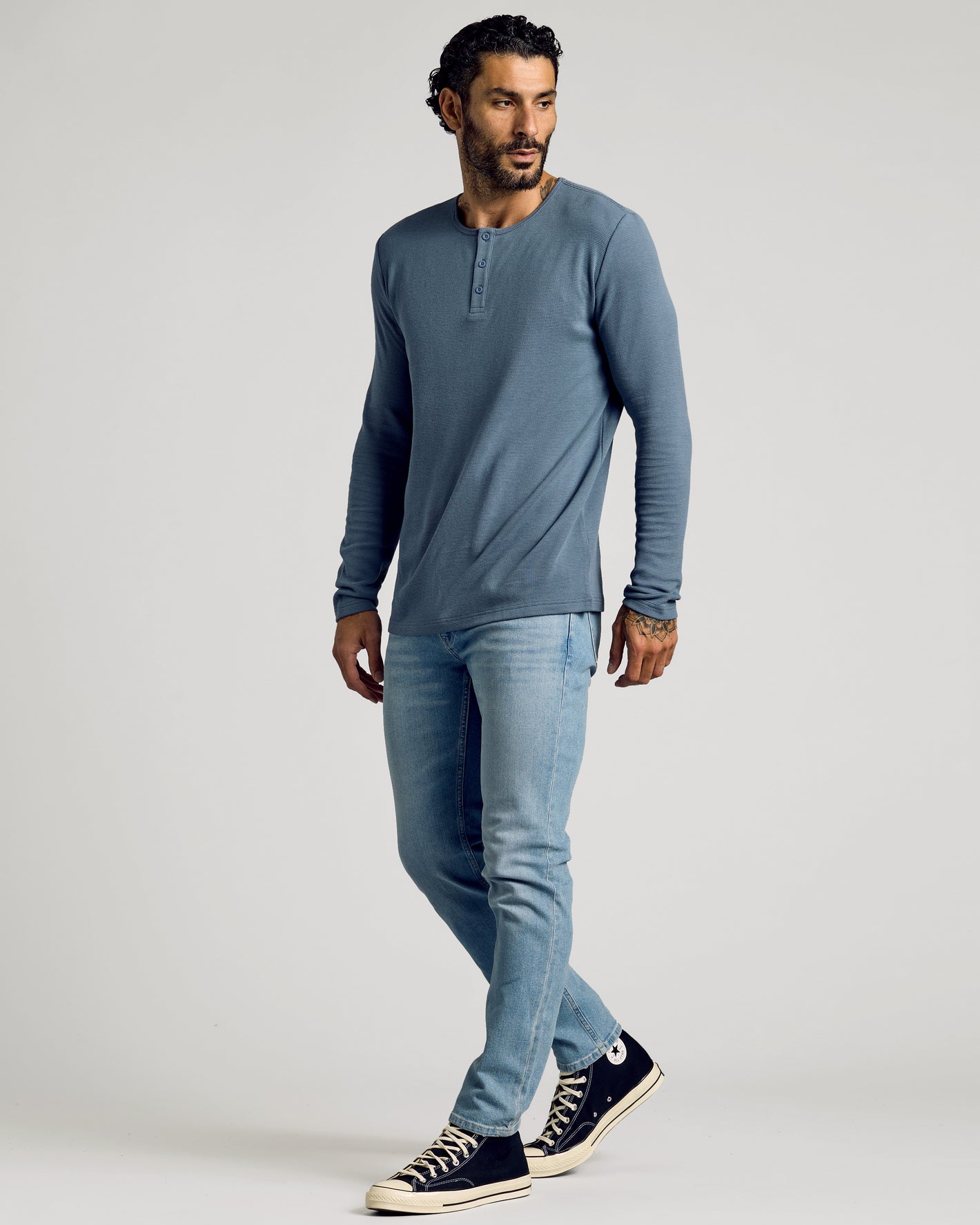 Model in Fiord Waffle Long Sleeve Henley with jeans and sneakers.