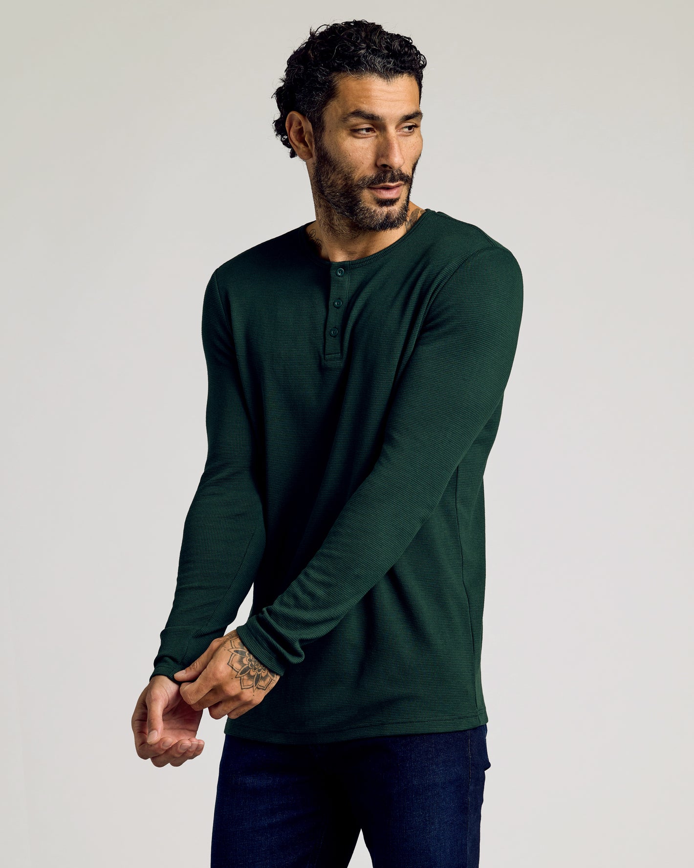 Model wearing Kale Waffle Long Sleeve Henley, adjusting sleeve.