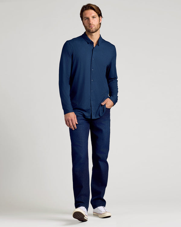 Man wearing a navy blue shirt and pants on a light gray background