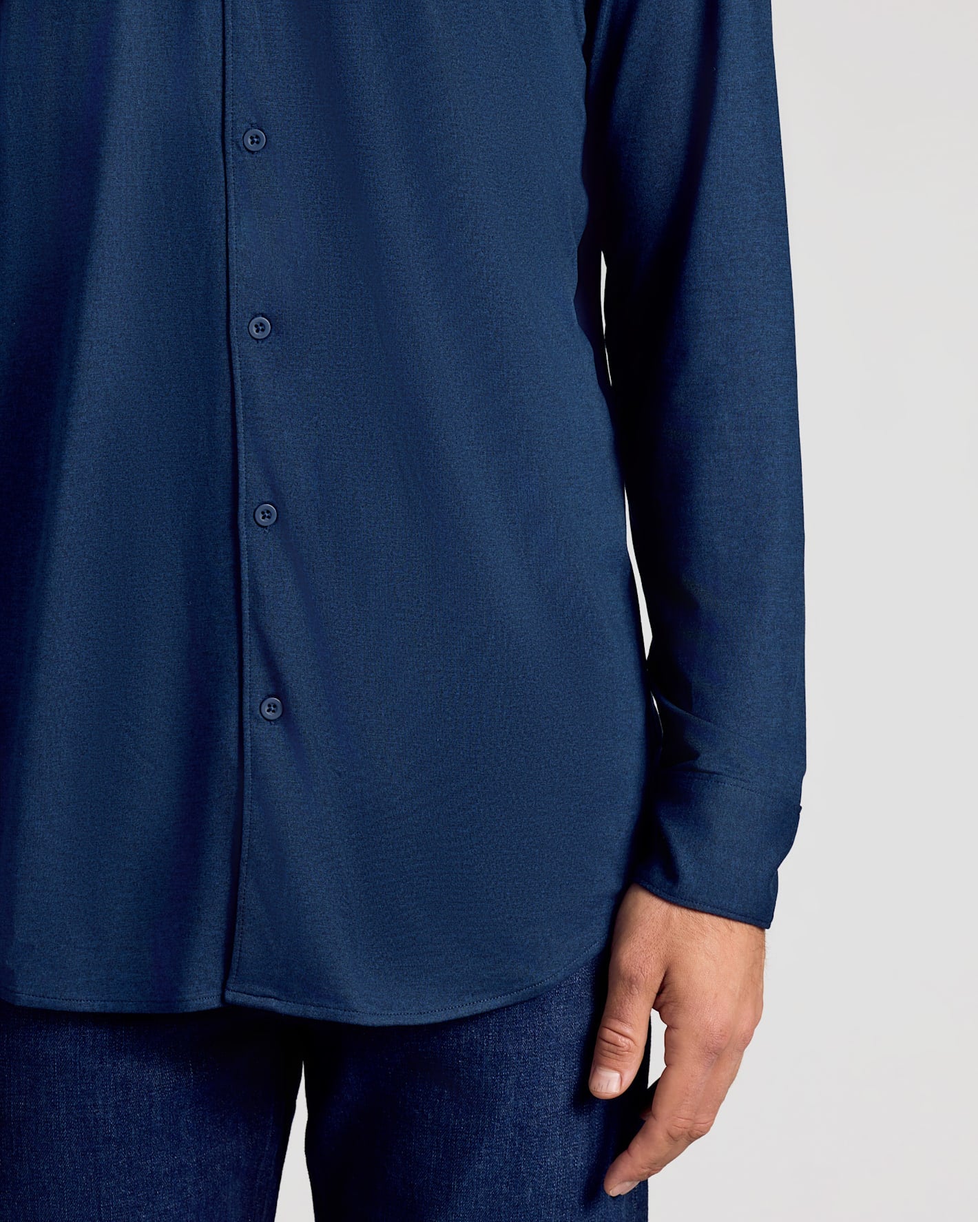 Navy blue button-up shirt worn by a person on a light gray background