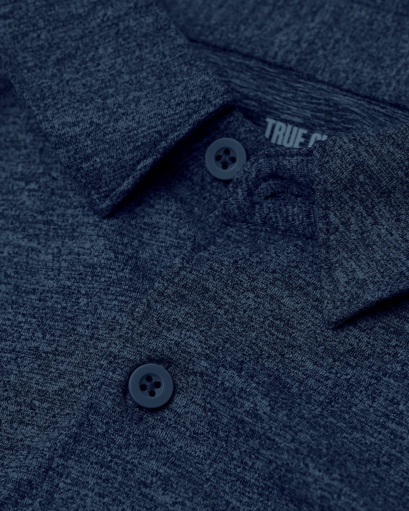 Close-up of a navy blue polo shirt with 'True Religion' branding.