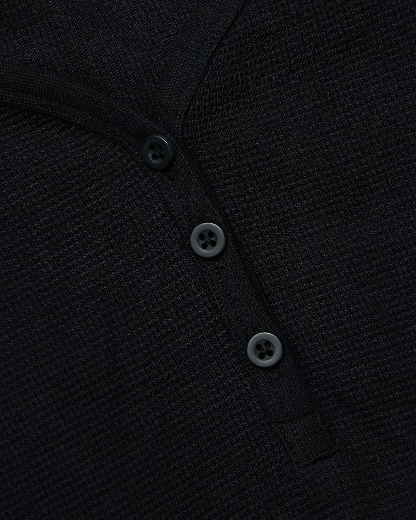 Close-up of Womens Black Waffle Long Sleeve Boxy Henley's button placket.