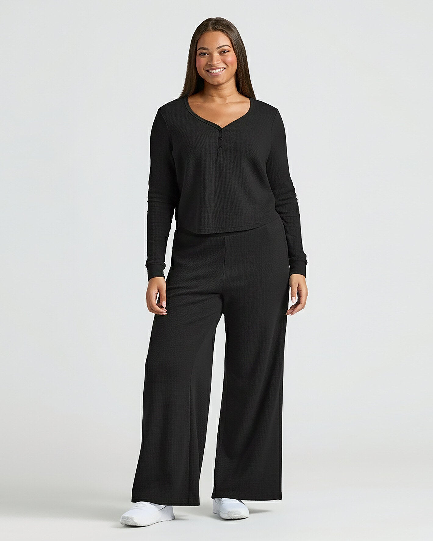 Woman wearing Womens Black Waffle Long Sleeve Boxy Henley lounge set, smiling.