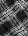 Onyx Plaid Long Sleeve Flannel Shirt close-up showing button and pocket seam.