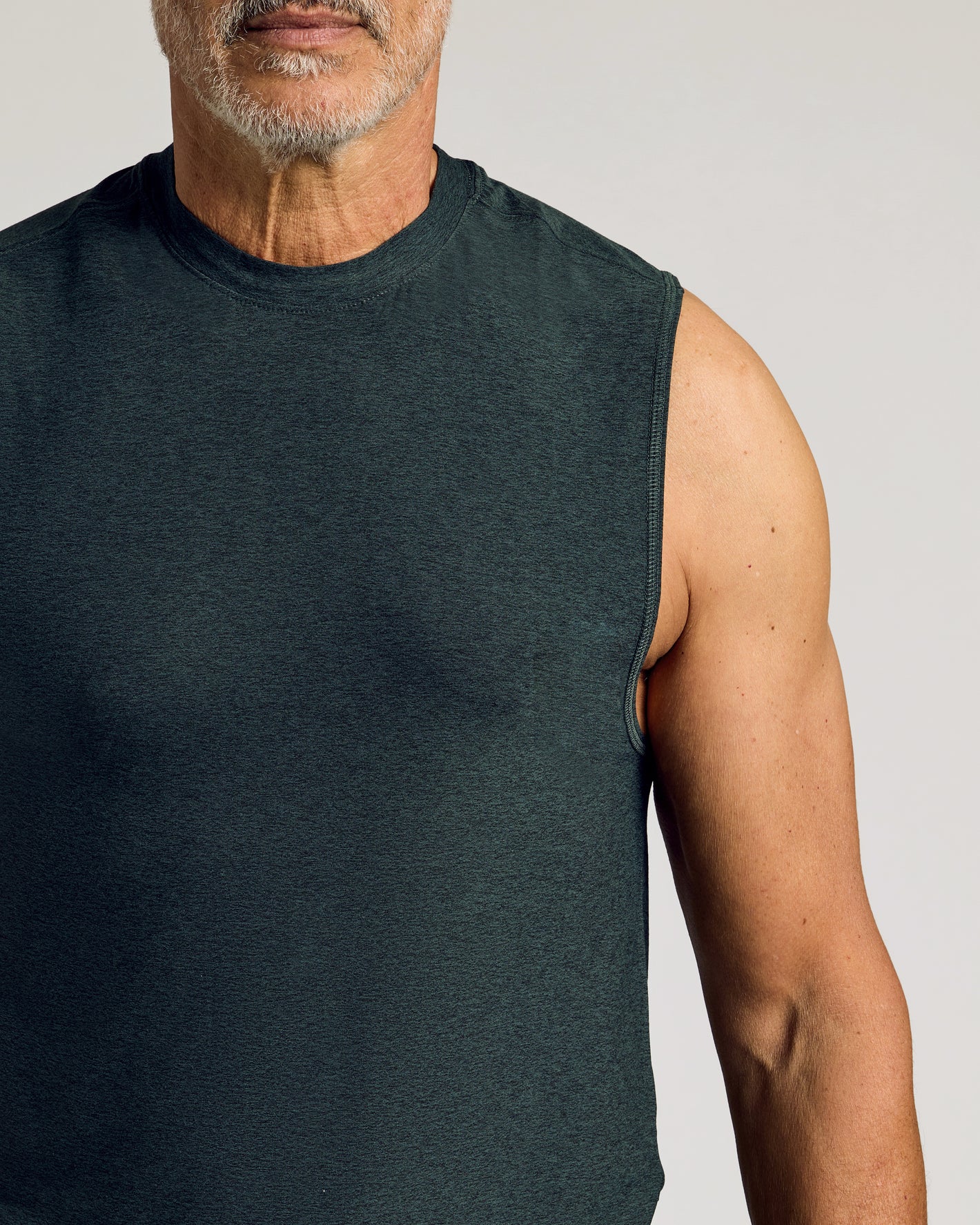 Man wearing Dark Heather Forest Sleeveless Active Muscle Tee.