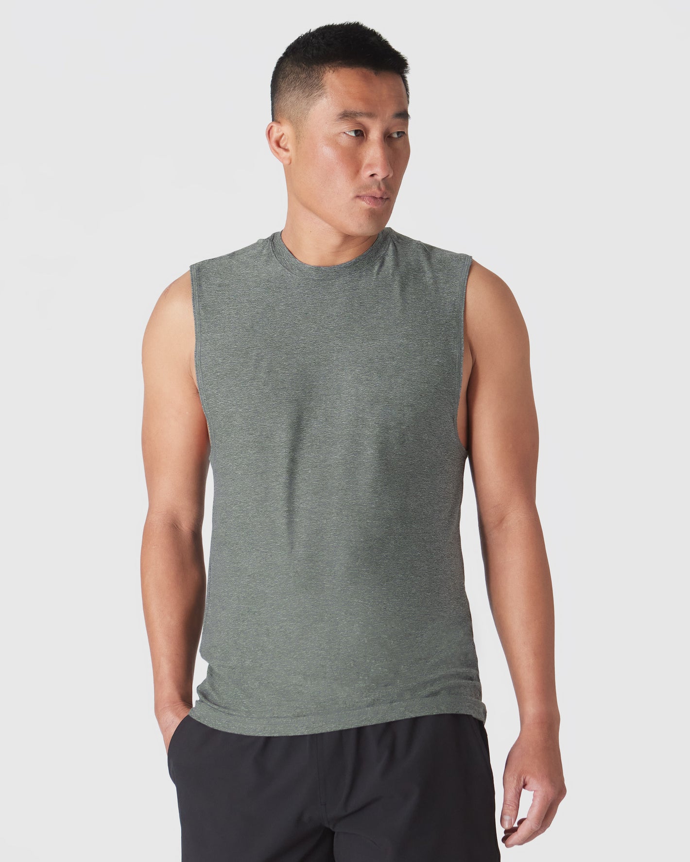 Male model wears Heather Forest Sleeveless Active Muscle Tee and black shorts.