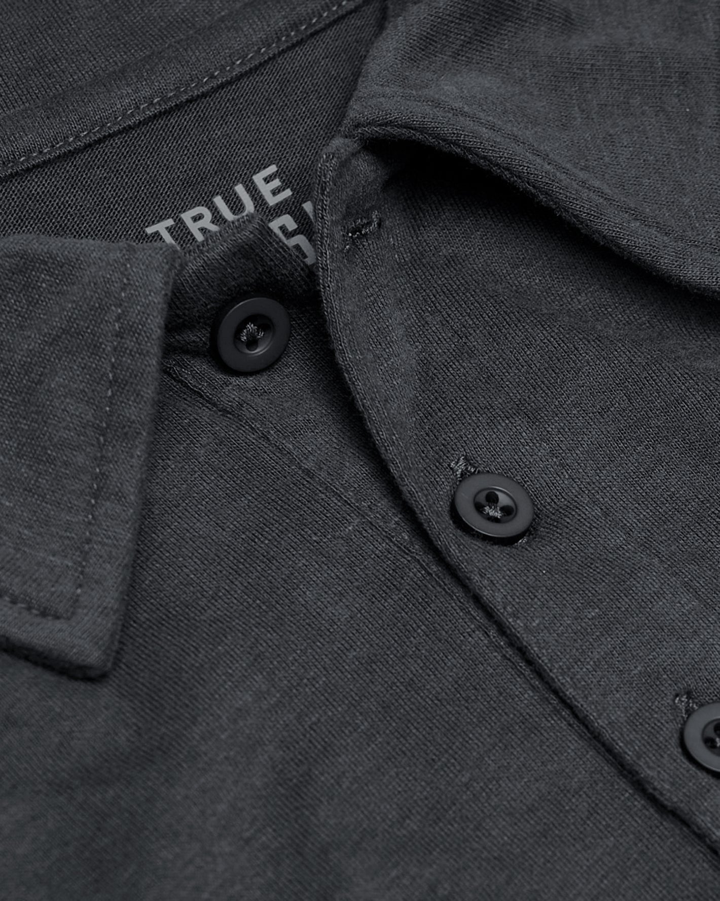 Carbon Short Sleeve Tall Polo, close-up of charcoal knit fabric, collar, buttons.
