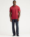 Man in Dark Heather Lava Short Sleeve Tall Polo, dark pants, black sneakers.