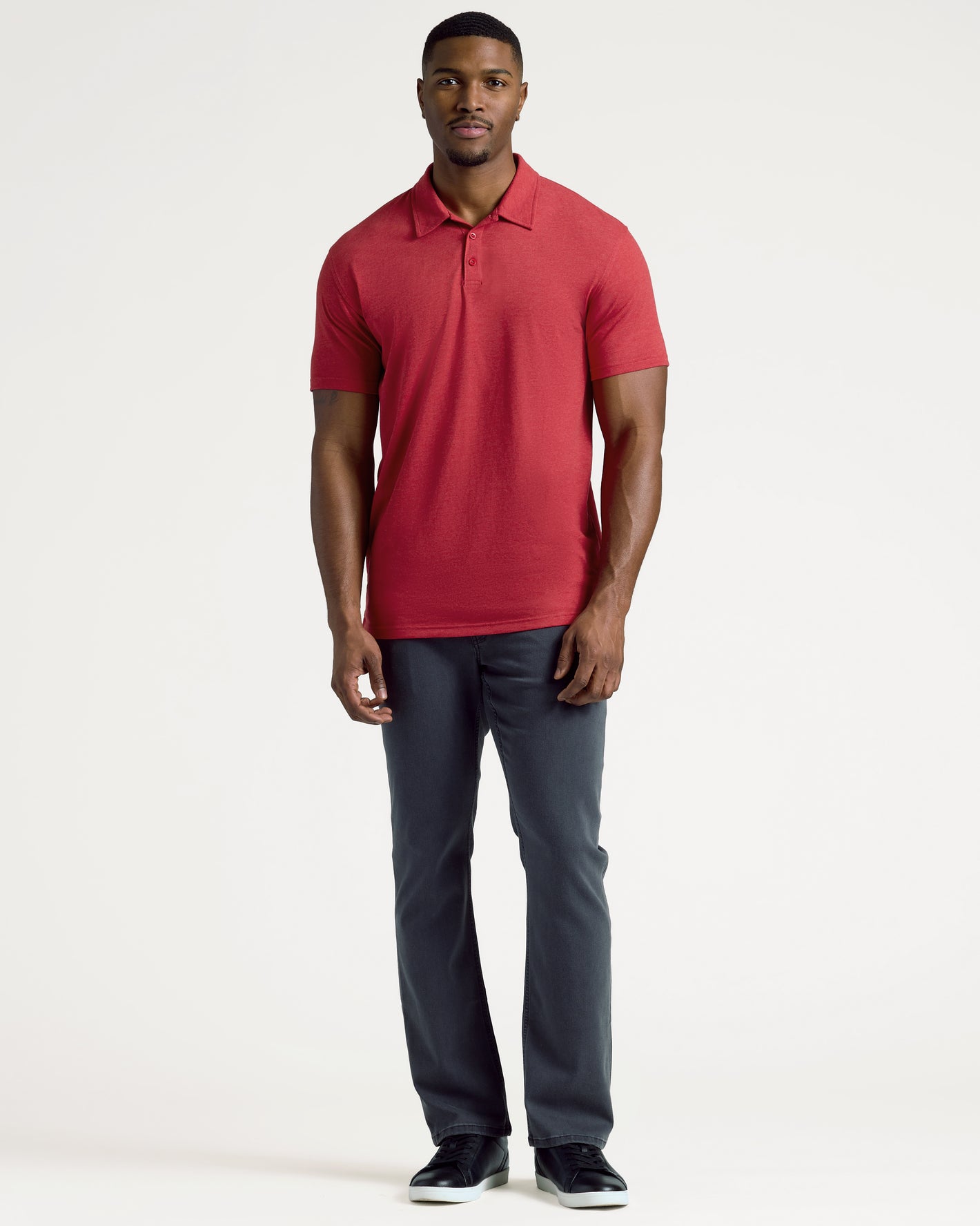 Man in Dark Heather Lava Short Sleeve Tall Polo, dark pants, black sneakers.