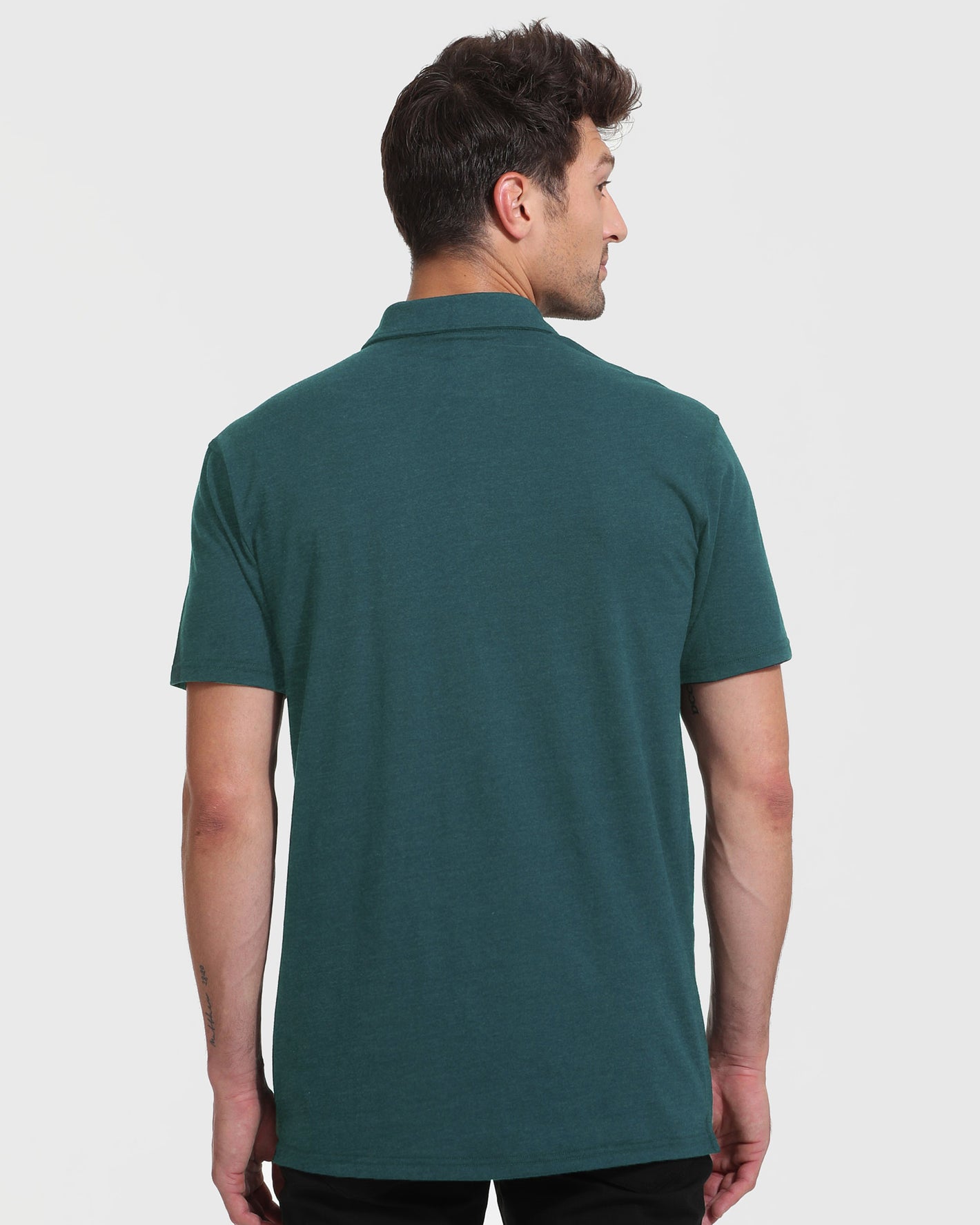 Man in Heather Seafarer Short Sleeve Tall Polo, side profile view.