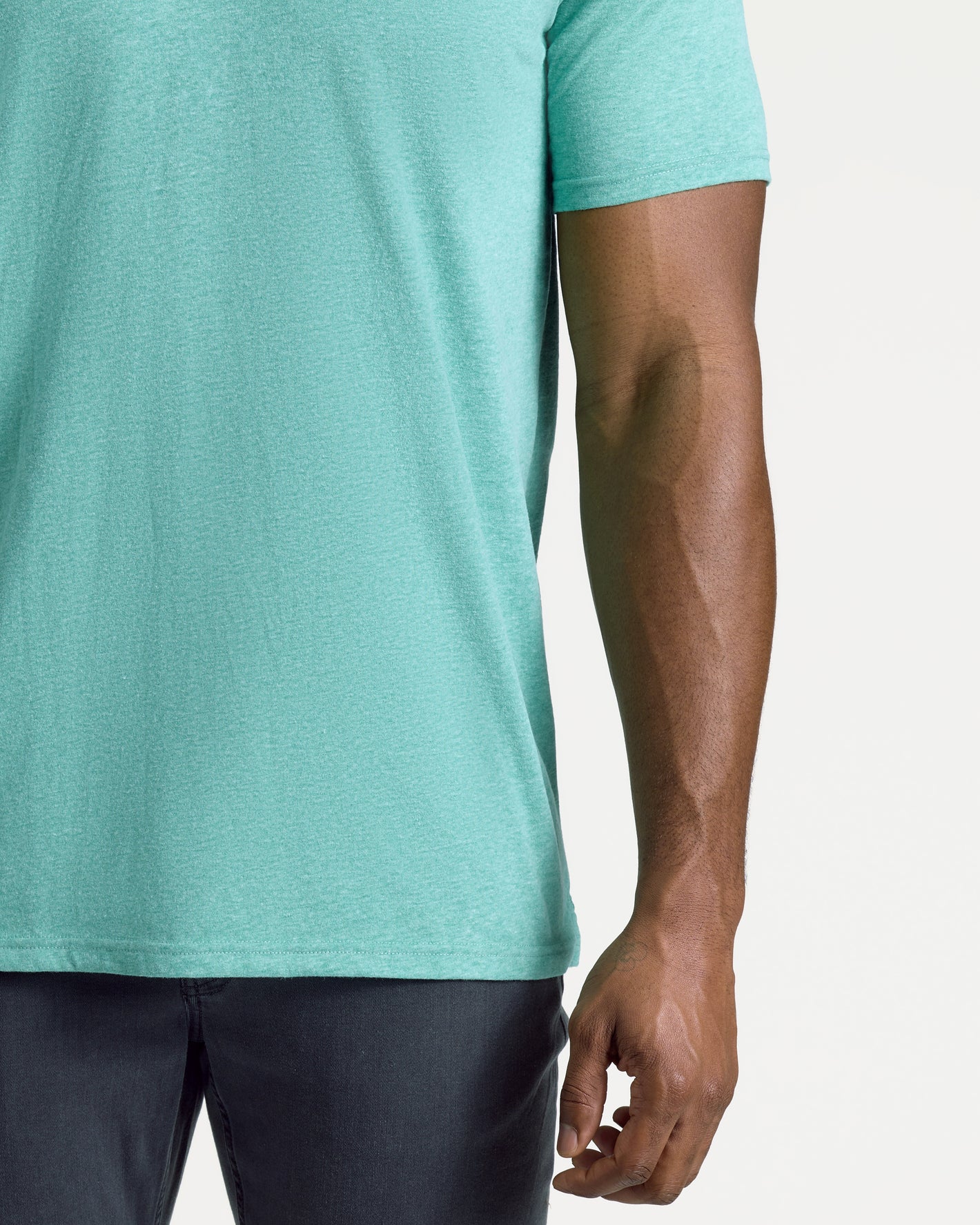 Person wearing Light Heather Greenery Short Sleeve Tall Polo, right arm visible.