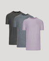 Three short-sleeve crew-neck t-shirts in dark charcoal gray, heather blue-gray, and light lavender purple, arranged in a layered overlapping display against a solid light gray background.