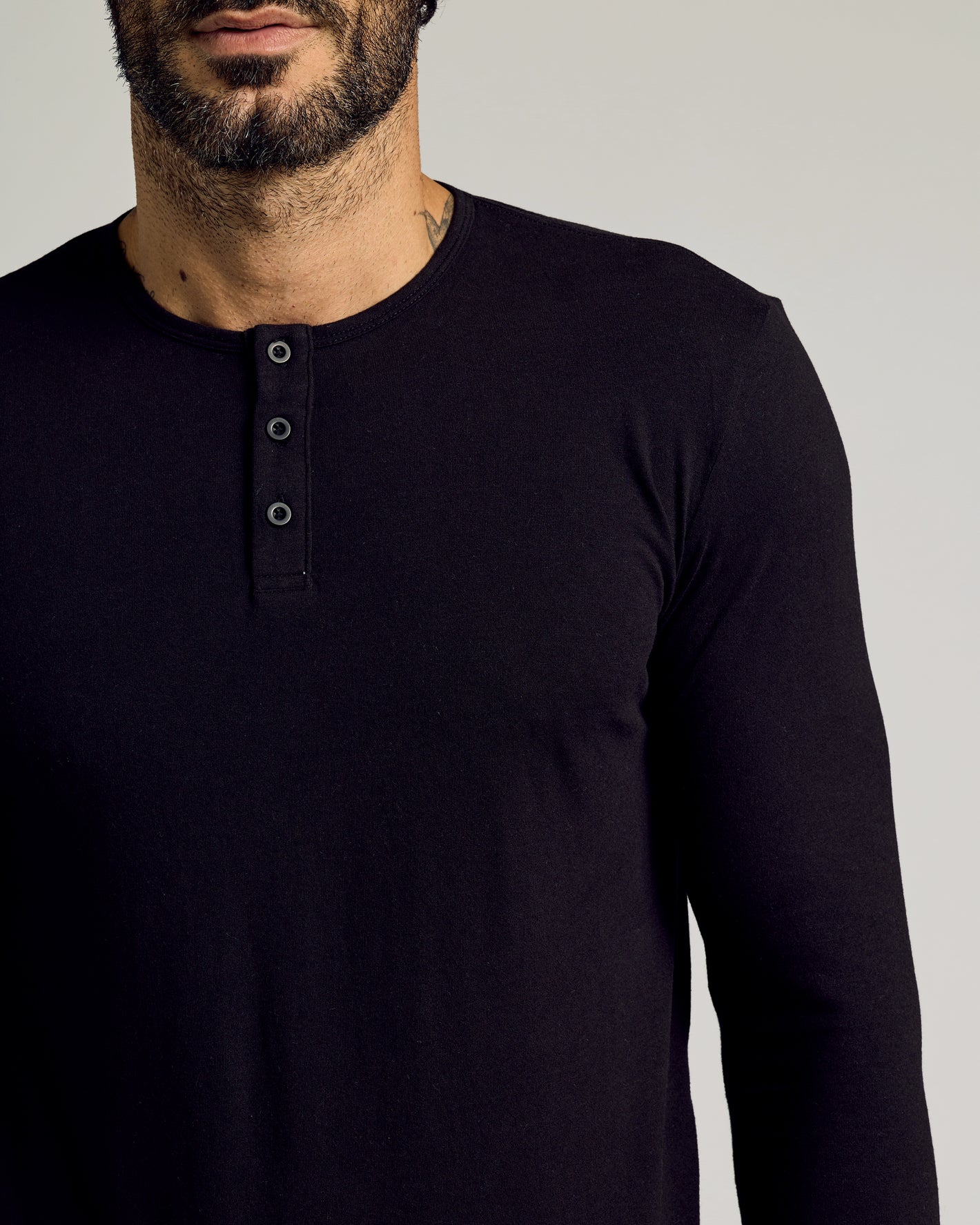 Man wearing All Black Tall Classic Long Sleeve Henley, buttoned placket visible.