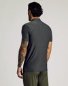 Man in Charcoal Heather Gray Short Sleeve Tall Active Polo, tattooed arm visible.