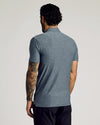 Man wearing Heather Navy Short Sleeve Tall Active Polo, showcasing tattooed arm.
