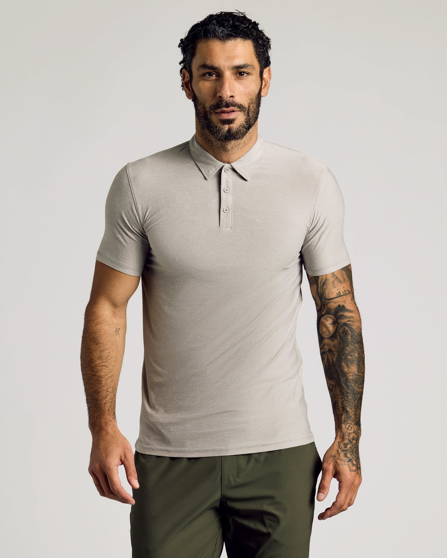 Man wearing Light Heather Gray Short Sleeve Tall Active Polo with olive pants.
