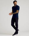 Man wearing Navy Short Sleeve Tall Active Polo, slim black joggers, athletic sneakers.