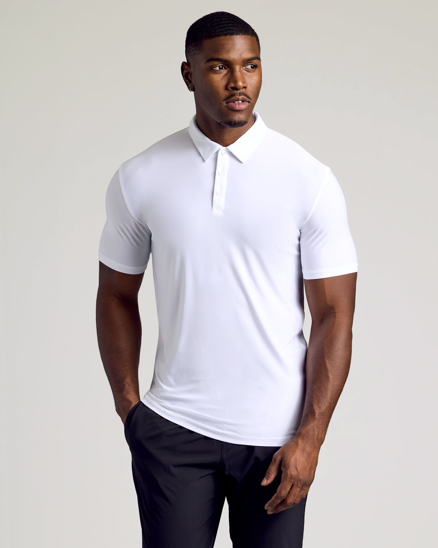 Man in White Short Sleeve Tall Active Polo, hands relaxed, minimal look.