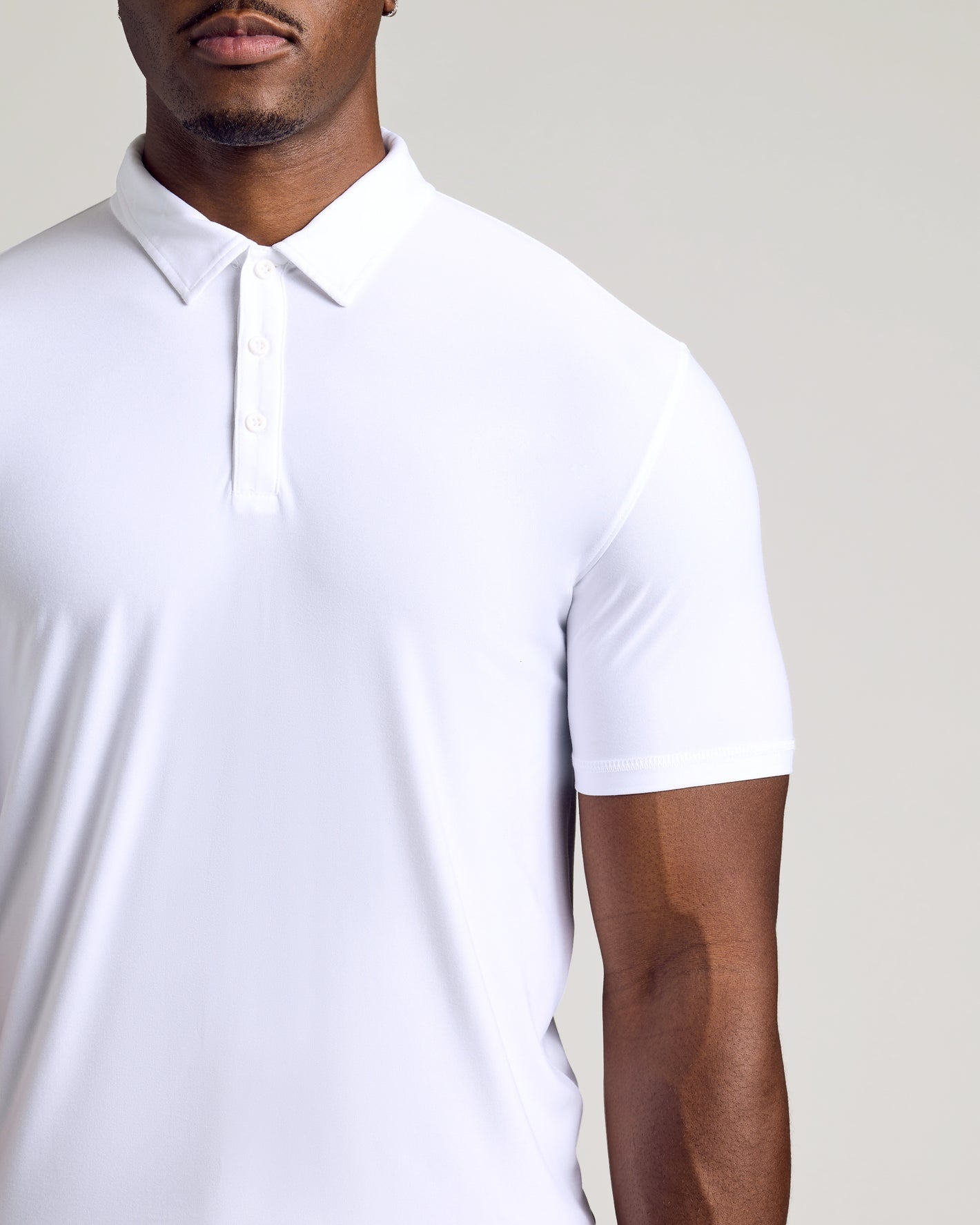 Man wearing White Short Sleeve Tall Active Polo, showcasing snug fit.