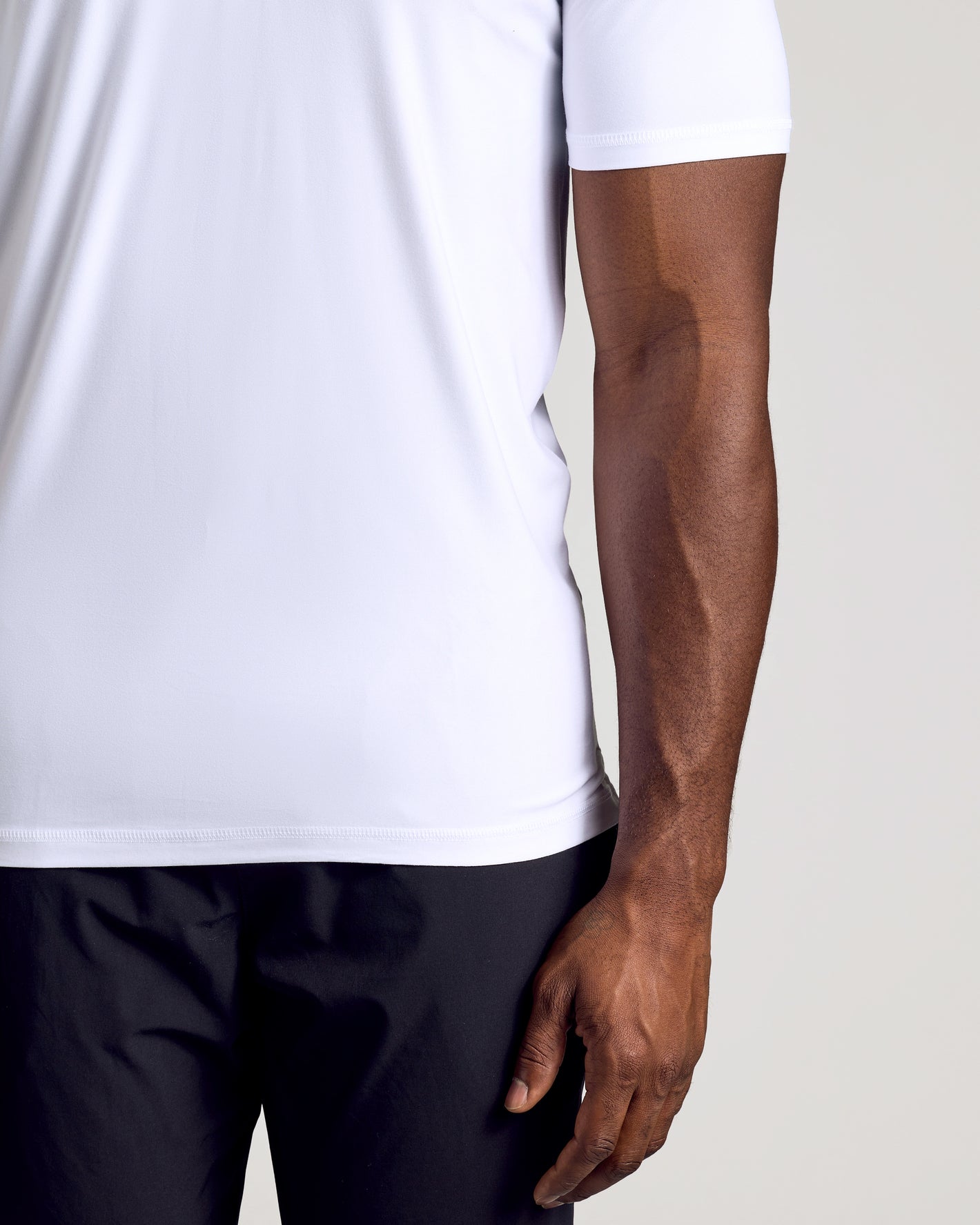 White Short Sleeve Tall Active Polo on person, showcasing fit and sleeve length.
