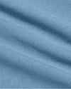 A close-up of a light blue knit fabric with soft diagonal folds and a fine ribbed texture.