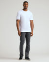 Man in White Tall Premium Pima Crew Neck, charcoal pants, black sneakers.