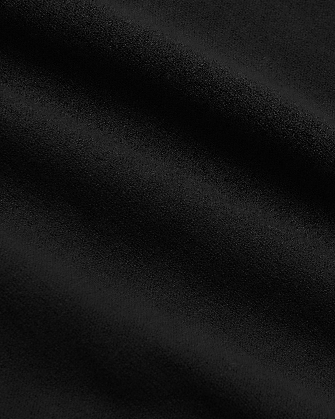 Close-up of Black Tall Dressy Polo's textured fabric with gentle ripples.