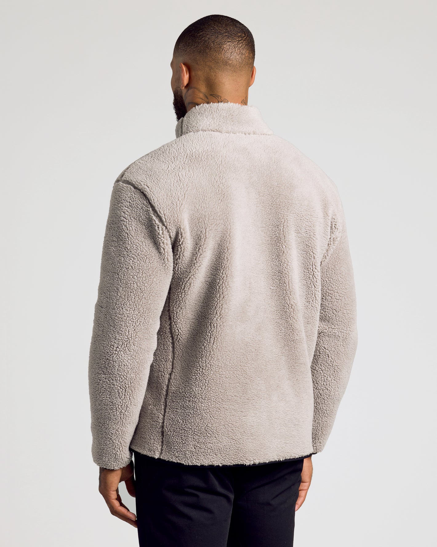 Man wearing Taupe Sherpa Full Zip Jacket, showcasing its cozy, fluffy texture.