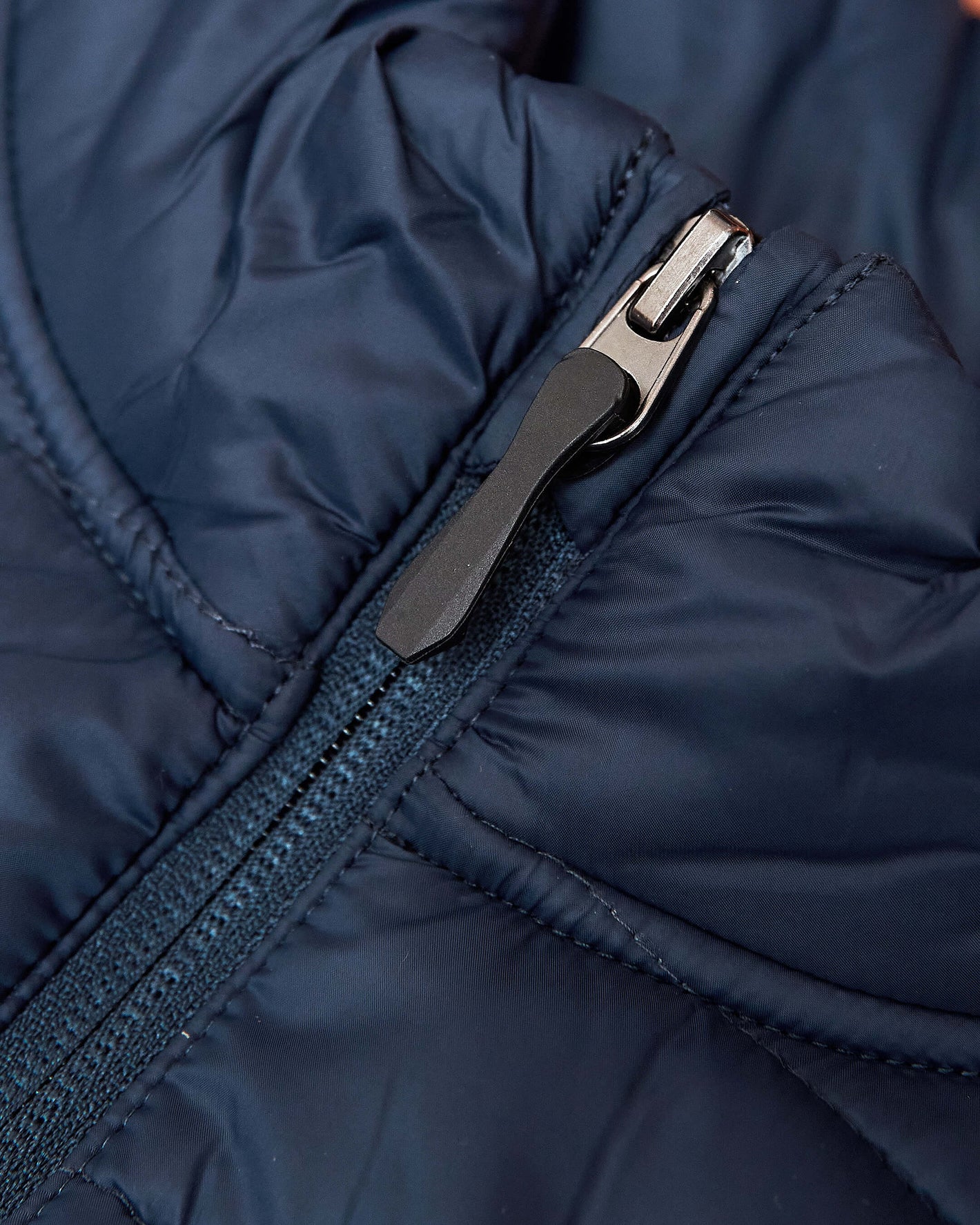Navy Puffer Vest close-up of quilted fabric and front zipper.
