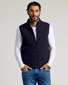 True ClassicMan wearing Black Puffer Vest over white shirt, hands in pockets.