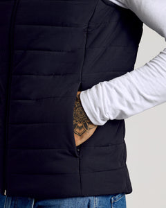 True ClassicBlack Puffer Vest over white T-shirt and blue jeans.