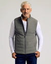 Man wearing Carbon Puffer Vest over white henley shirt.