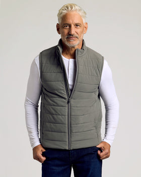 Man wearing Carbon Puffer Vest over white henley shirt.