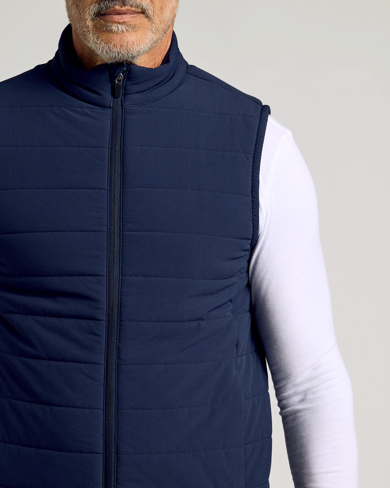 Navy Puffer Vest over white shirt, showcasing sleek design.