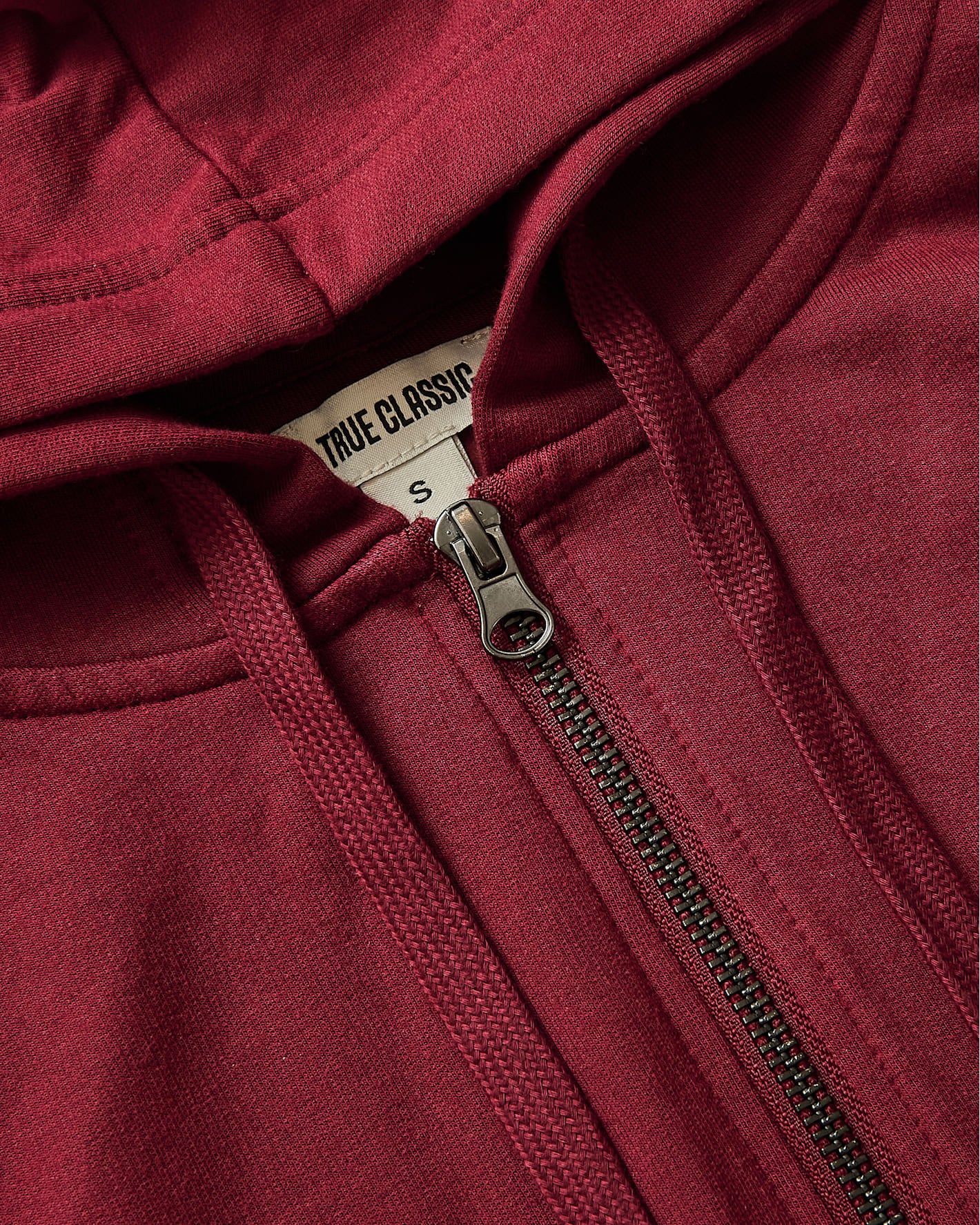 Womens Dark Maroon Crop Zip Hoodie showing zipper, drawcords, and label.
