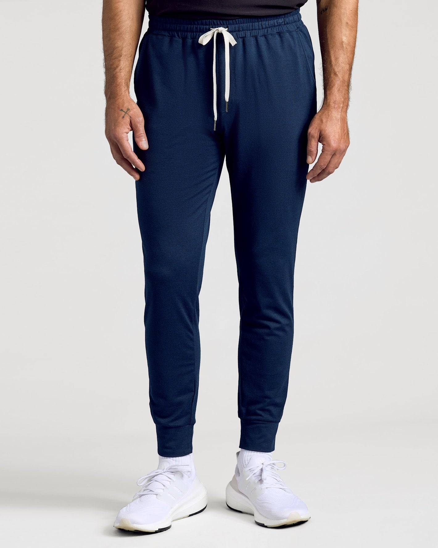 Dark Heather Navy joggers with drawstring, cuffed ankles, and white sneakers.