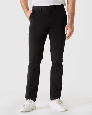 Black Slim Twill Chino Pant with white sneakers in a studio setting.