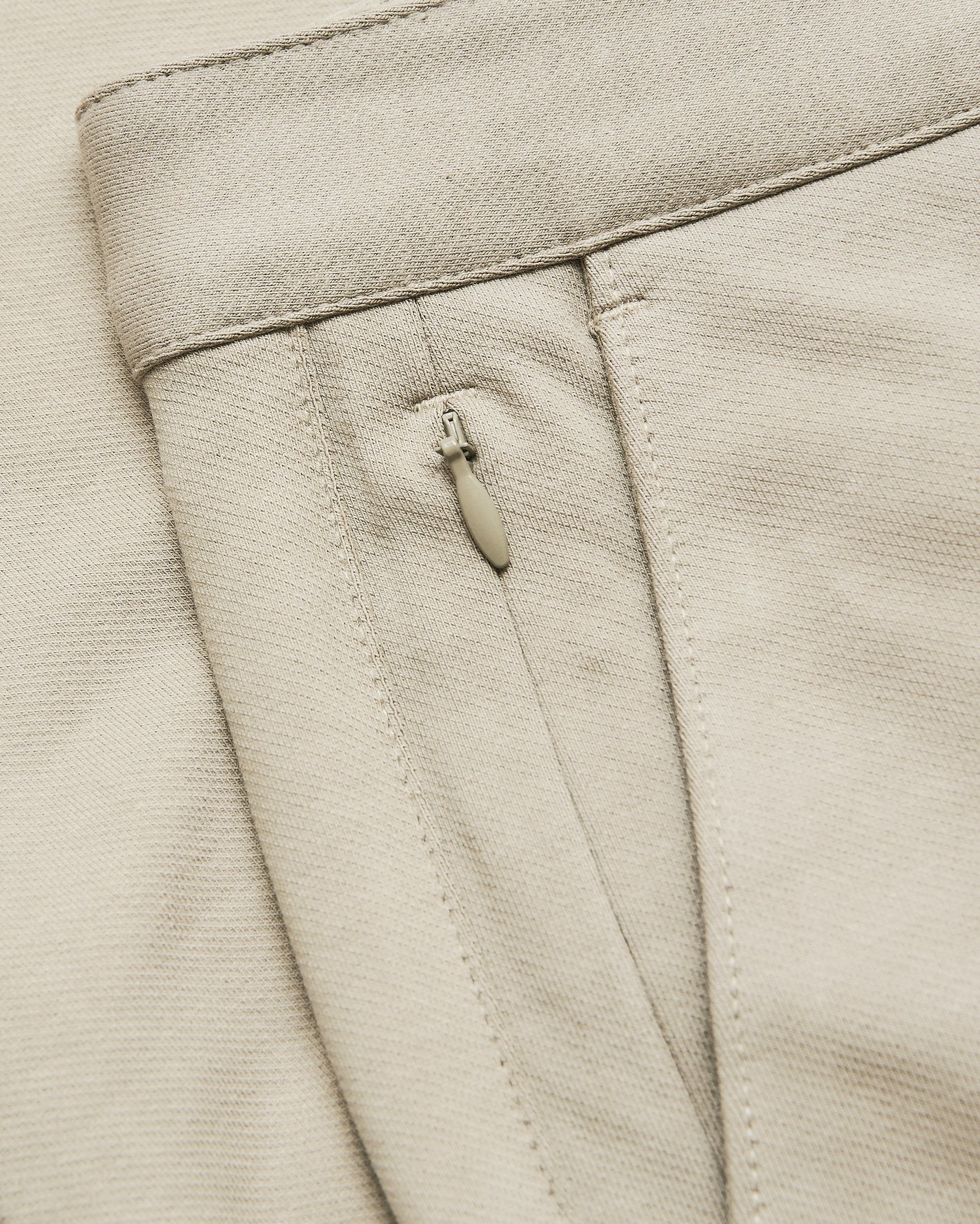 Sandstone Slim Chino Pants 2.0 waistband and zipper pocket detail.