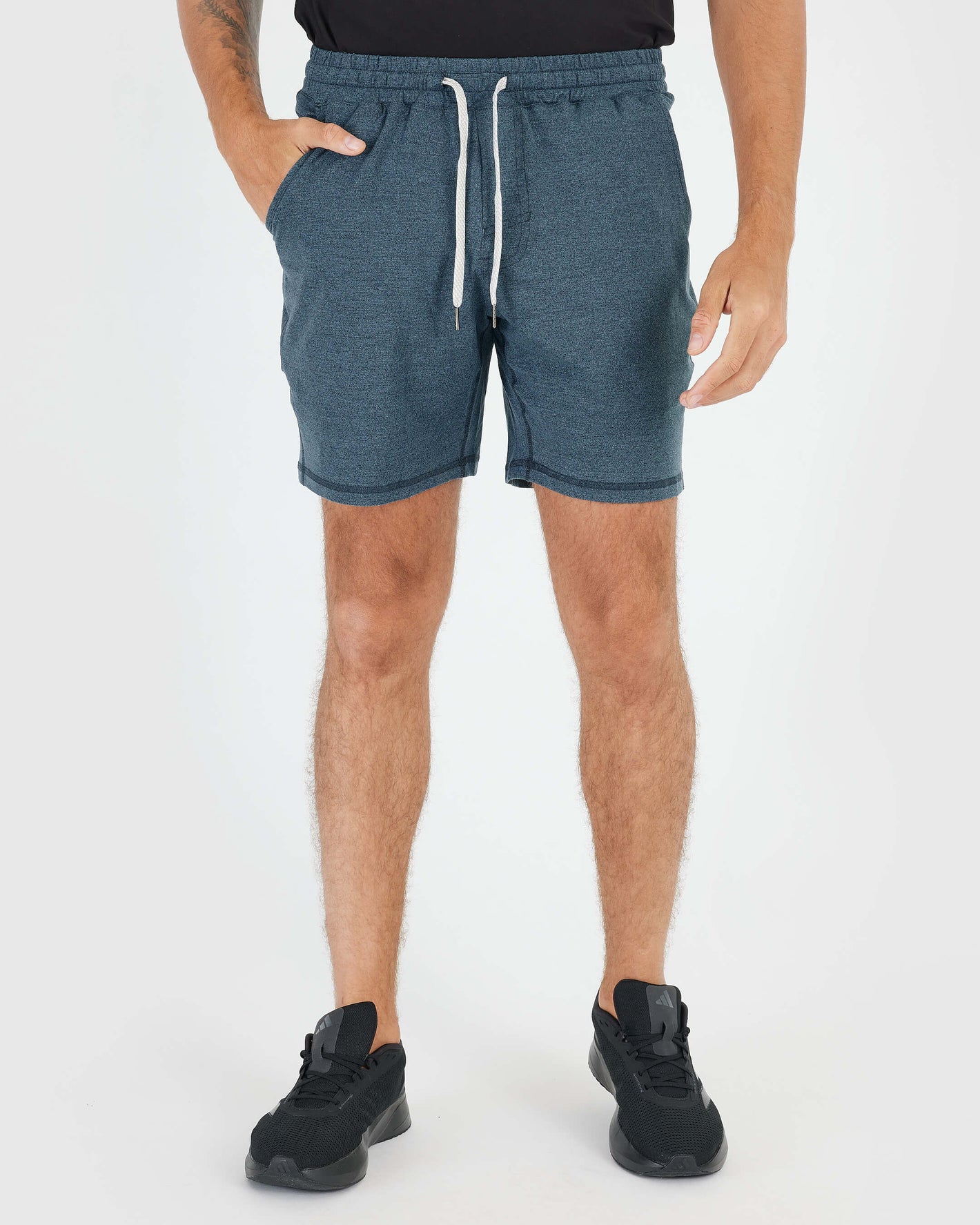 Man in Dark Heather Indigo Active Comfort Shorts with sneakers.