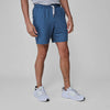 Man wearing Stone Blue Active Comfort Shorts with white sneakers.