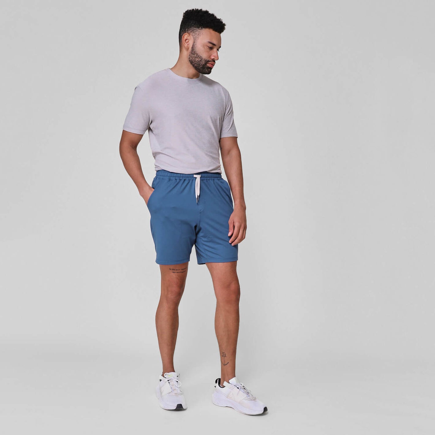 Man wearing Stone Blue Active Comfort Shorts, light-gray t-shirt, white sneakers.