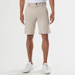 Sandstone Neutral Chino Shorts, knee-length with white sneakers.